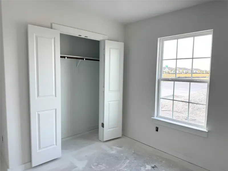 Unfurnished bedroom featuring concrete flooring and a closet Unfurnished bedroom featuring concrete flooring and a closet