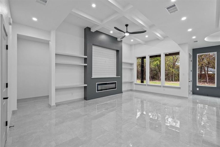 Unfurnished living room with beam ceiling, built in features, ceiling fan, and coffered ceiling