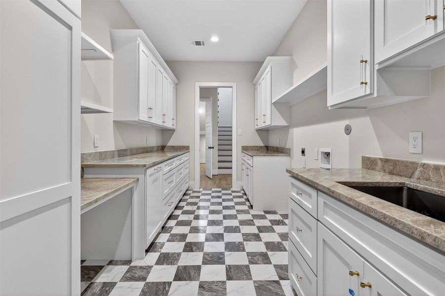 A stylish and efficient laundry space with custom cabinetry. Ample storage and workspace make everyday tasks effortless.