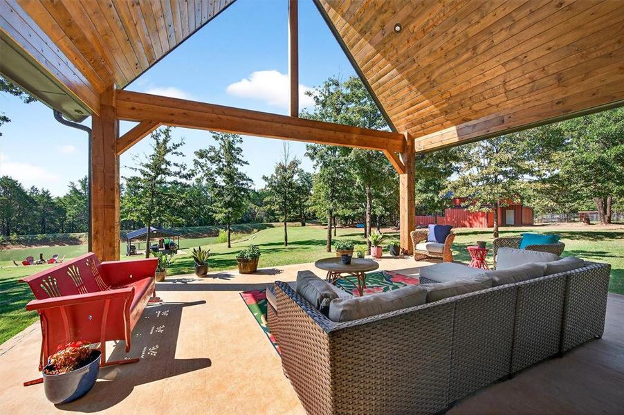 View of patio with an outdoor hangout area, an outdoor structure, and view of scattered trees View of patio with an outdoor hangout area, an outdoor structure, and view of scattered trees