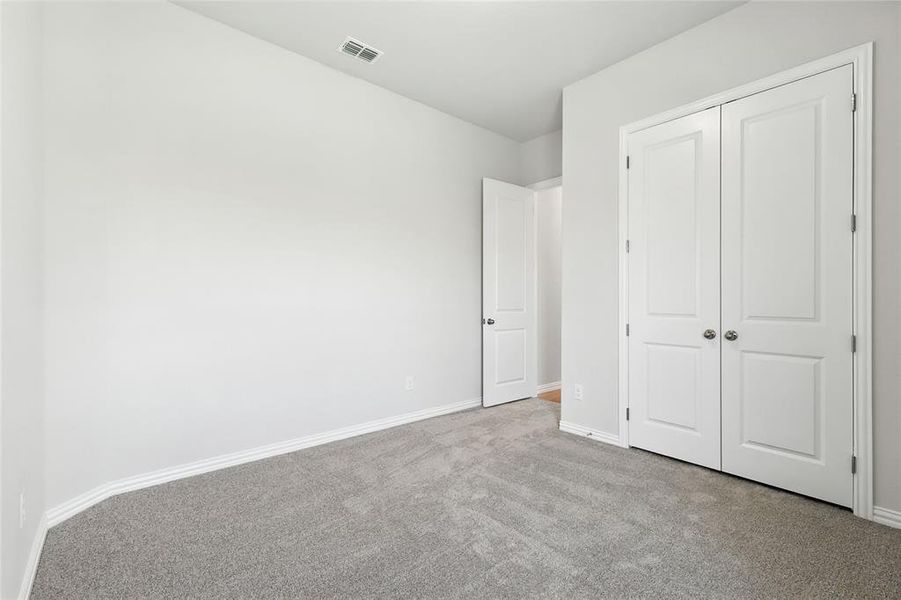 Unfurnished bedroom featuring carpet floors and a closet Unfurnished bedroom featuring carpet floors and a closet