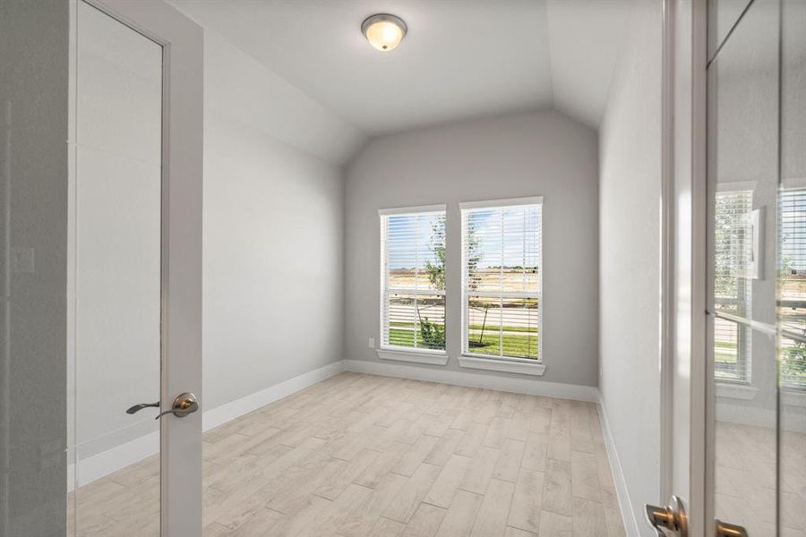 At the forefront, a refined home office beckons productivity and focus. Luxurious details like elegant tile, custom paint, expansive windows with privacy blinds, and French doors create an inspiring workspace. Sample photo of completed home with similar floor plan. Actual colors and selections may vary.