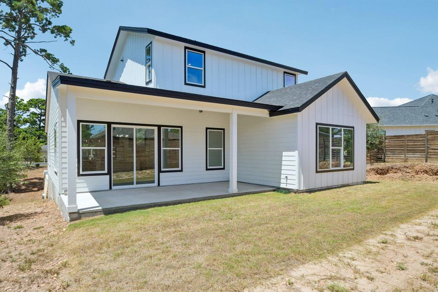 A spacious covered patio overlooks the grassy backyard of this modern board-and-batten home. A spacious covered patio overlooks the grassy backyard of this modern board-and-batten home.