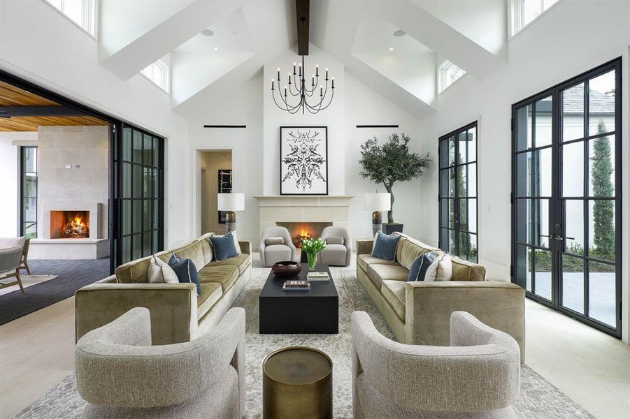 Great room with gas fireplace, vaulted ceiling, and large floor to ceiling doors