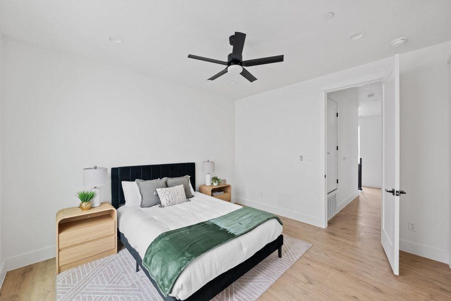 Bedroom featuring light wood-finish flooring, white walls, and recessed lighting