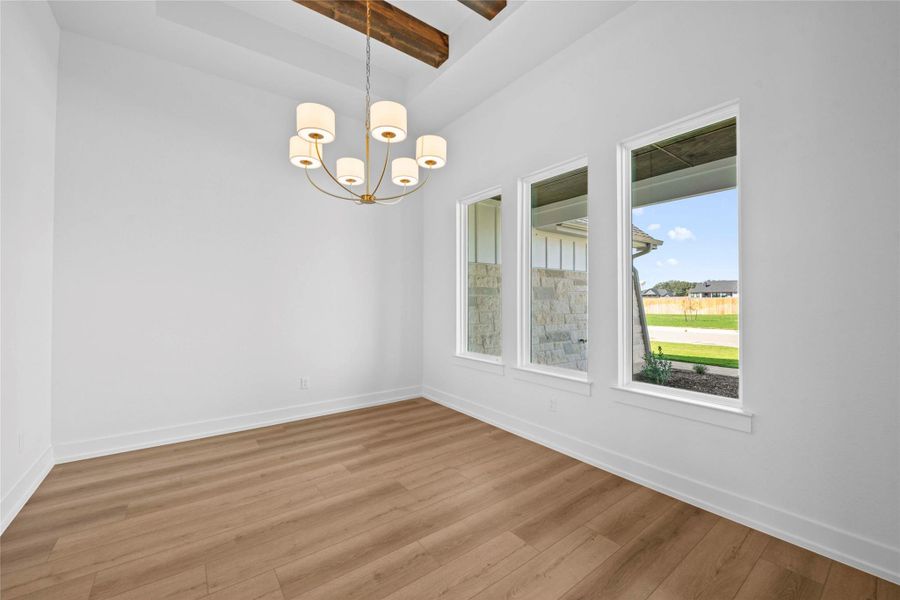Unfurnished dining area with wood finished floors, beam ceiling, and a chandelier Unfurnished dining area with wood finished floors, beam ceiling, and a chandelier