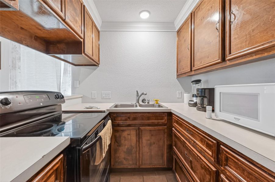 Second-level kitchen featuring wood cabinetry, generous counter space, and efficient layout.