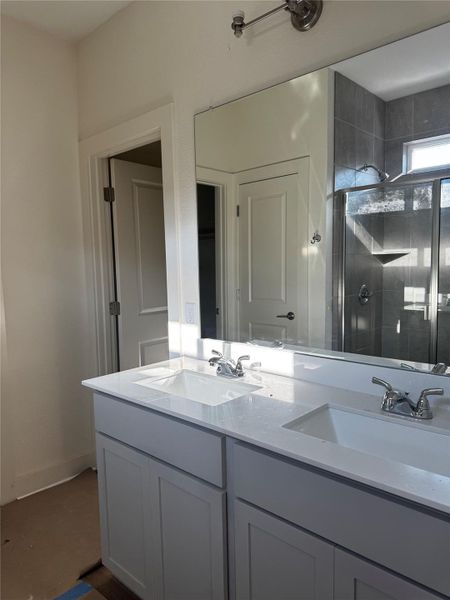Full bathroom featuring a shower stall and double vanity Full bathroom featuring a shower stall and double vanity