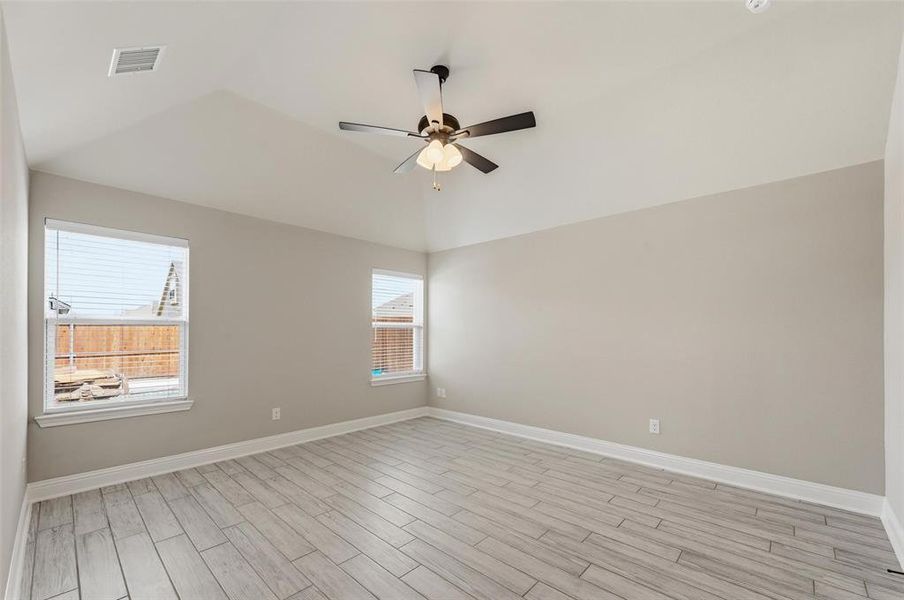 Empty room featuring wood tiled floors, a ceiling fan, and lofted ceiling Empty room featuring wood tiled floors, a ceiling fan, and lofted ceiling