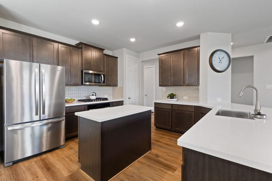 Quartz countertops, designer backsplash and plenty of counter and cabinet space make entertaining or feeding the family a breeze.