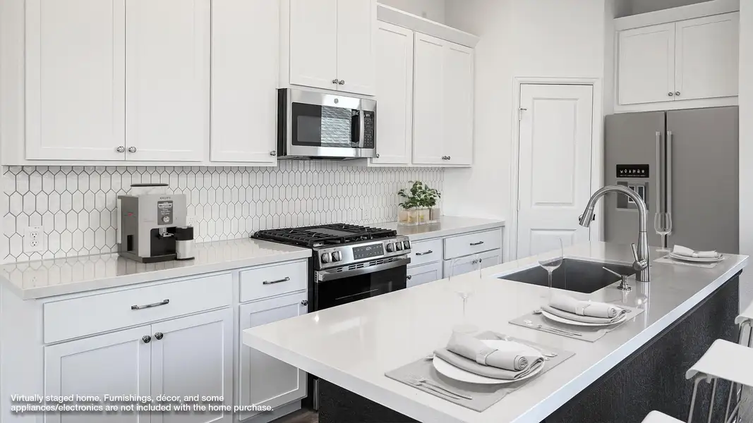 Kitchen with white cabinets, stainless steel appliances, backsplash, and light stone counters Kitchen with white cabinets, stainless steel appliances, backsplash, and light stone counters