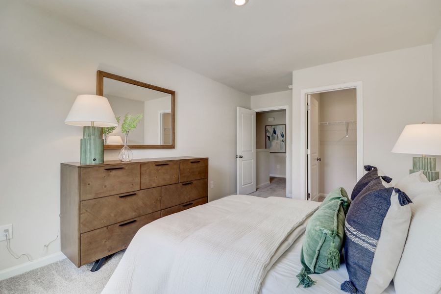A bedroom with a bed and a dresser.