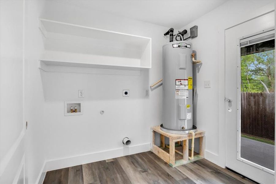 Laundry room with dark hardwood / wood-style flooring, electric water heater, gas dryer hookup, and hookup for an electric dryer