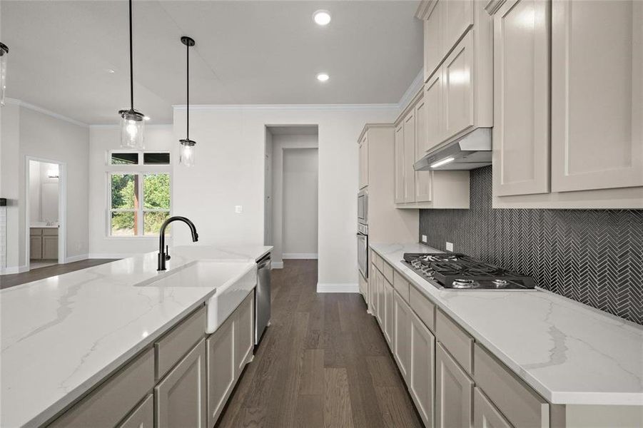 Kitchen featuring dark hardwood / wood-style floors, black gas stovetop, decorative light fixtures, light stone countertops, and stainless steel dishwasher