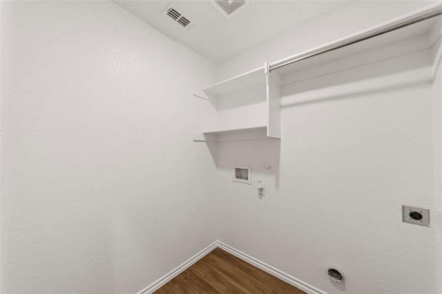 Laundry room with hookup for a gas dryer, baseboards, dark wood-type flooring, electric dryer hookup, and hookup for a washing machine Laundry room with hookup for a gas dryer, baseboards, dark wood-type flooring, electric dryer hookup, and hookup for a washing machine