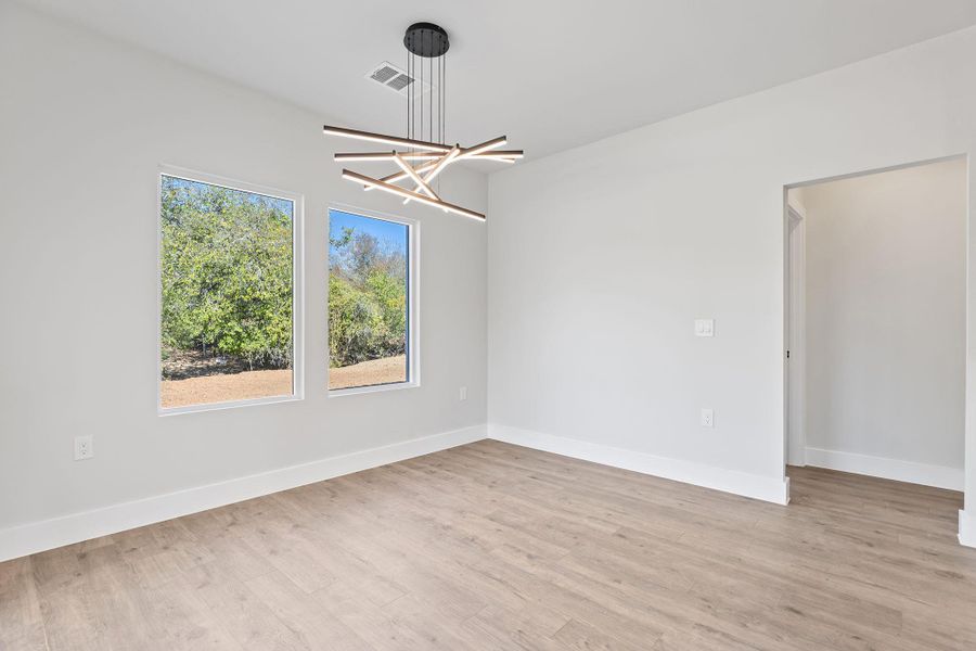 Unfurnished dining area featuring light wood-style flooring and a chandelier