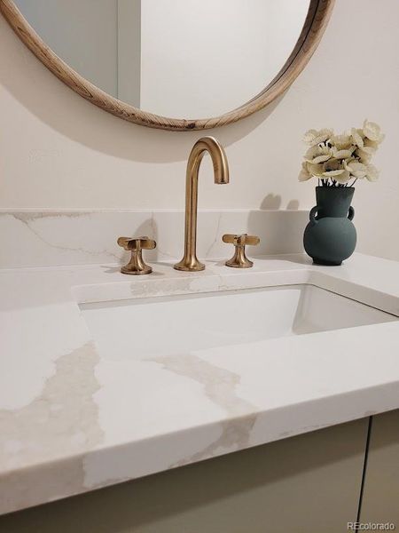 Simple and timeless finishes, quartz countertop, soft brass faucet