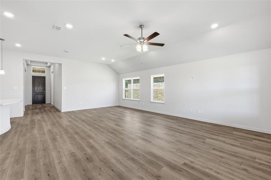 Unfurnished living room featuring recessed lighting, vaulted ceiling, a ceiling fan, and light wood-style flooring