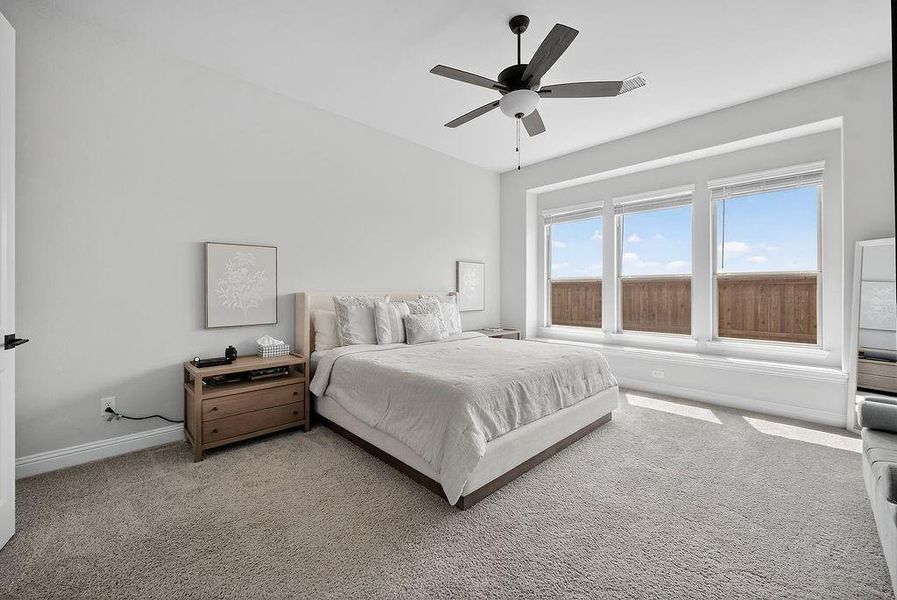 Carpeted room featuring a ceiling fan with integrated lighting, three large windows, light gray wall paint, and white trim