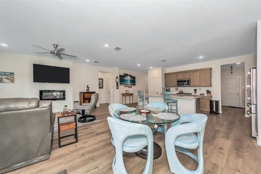 Dining space with ceiling fan and light hardwood / wood-style floors