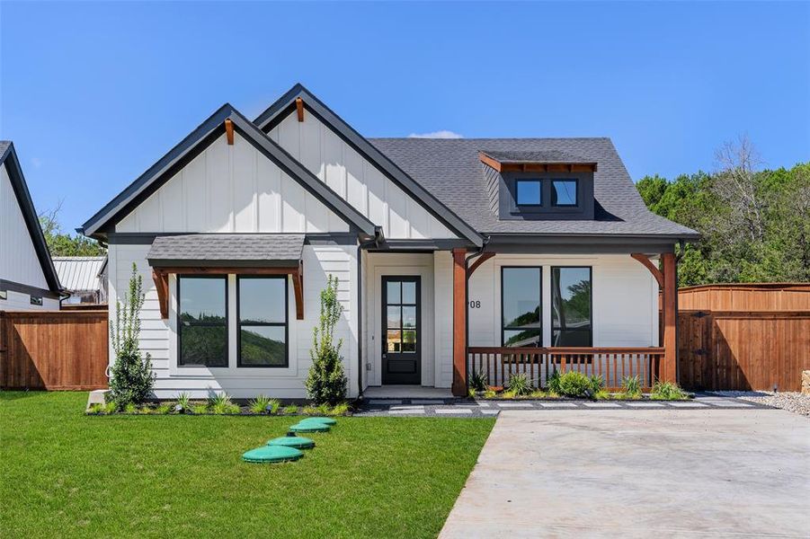 Modern inspired farmhouse featuring a front lawn and a porch