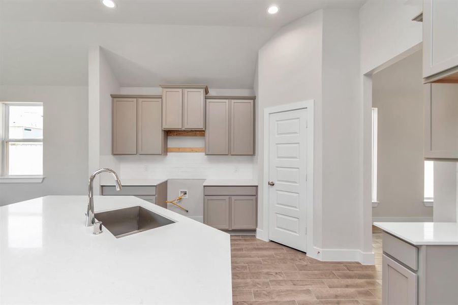 Discover another perspective of this stunning kitchen, generously appointed with an abundance of counter space. Sample photo of completed home. Actual colors and selections may vary.