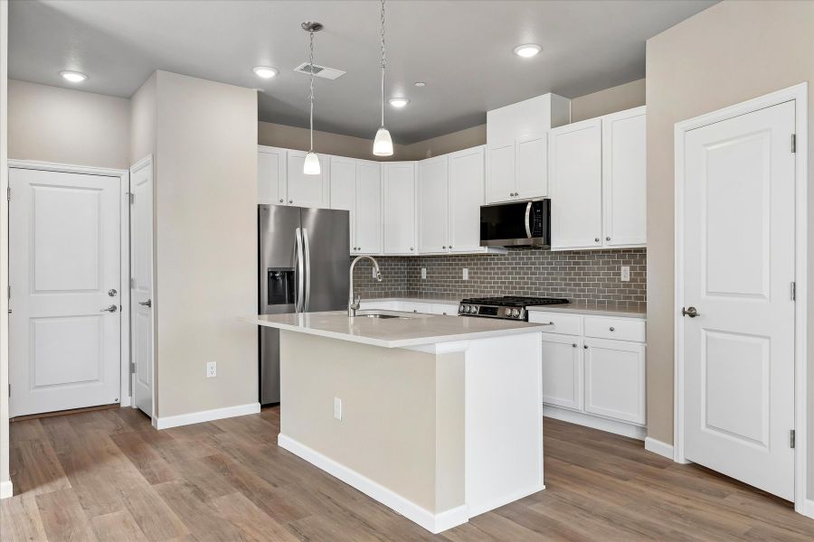 A kitchen with white cabinets.