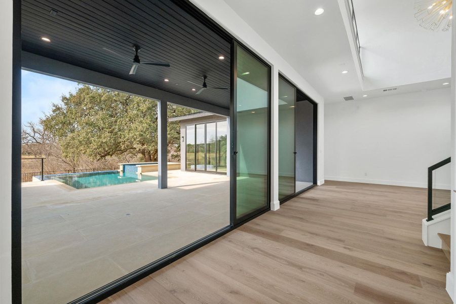 Doorway to outside featuring wood finished floors, floor to ceiling windows, recessed lighting, and ceiling fan
