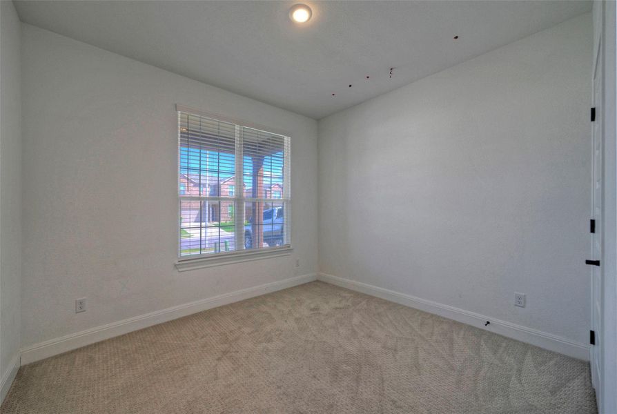 Soft carpeting pairs with neutral walls and a large window in this versatile space. Soft carpeting pairs with neutral walls and a large window in this versatile space.