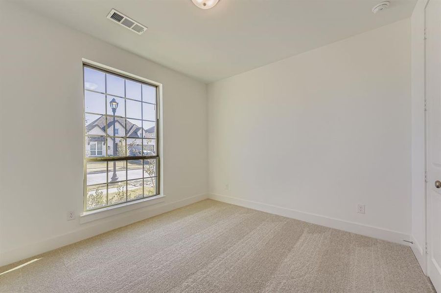 Unfurnished room with light carpet and baseboards Unfurnished room with light carpet and baseboards