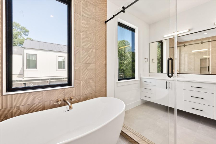 Bathroom with vanity, a freestanding bath, tile patterned flooring, and a shower stall