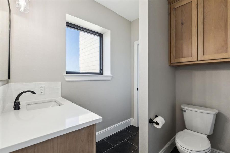 Bathroom featuring vanity, toilet, baseboards, and tile patterned floors Bathroom featuring vanity, toilet, baseboards, and tile patterned floors