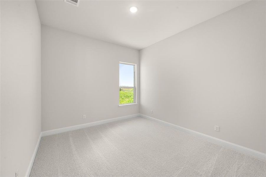 Spare room with baseboards and light colored carpet