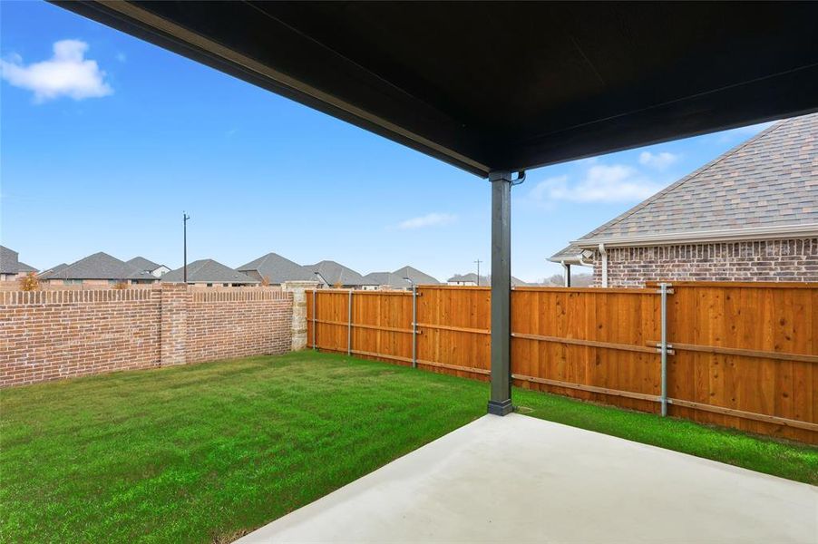 Fenced backyard with a patio area and a residential view