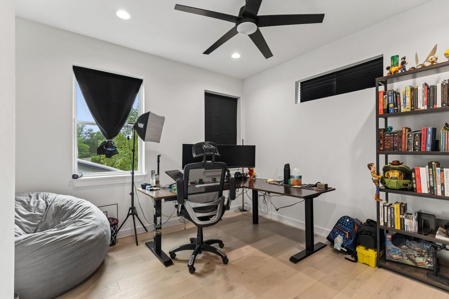 Light-filled interior space featuring wood-finish flooring, recessed lighting, and a ceiling fan