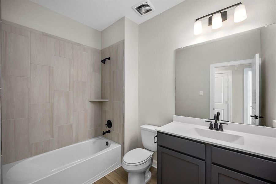 Step into the secondary bathroom, where a sleek vanity and mirror create a polished look, and the tub-shower combo ensures versatility for bathing preferences. With its thoughtful design and efficient layout, this bathroom offers both functionality and comfort.