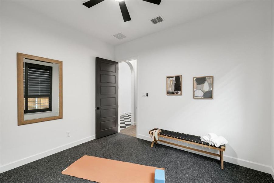 Carpeted bedroom featuring a ceiling fan and arched walkways Carpeted bedroom featuring a ceiling fan and arched walkways