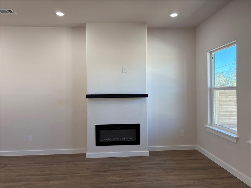 Unfurnished living room featuring recessed lighting, dark wood-style floors, and a fireplace