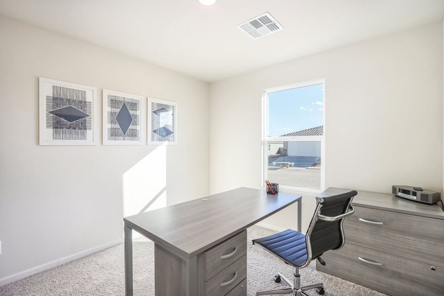 An office with a desk and chairs.