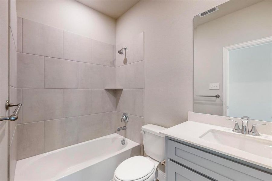 Full bathroom featuring vanity, toilet, and tiled shower / bath