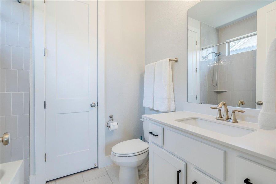 Full bathroom with vanity, light tile patterned flooring, and shower / washtub combination Full bathroom with vanity, light tile patterned flooring, and shower / washtub combination
