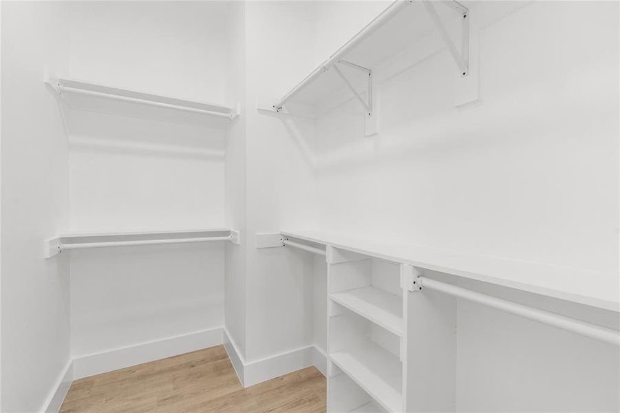 Walk in closet featuring light wood-type flooring Walk in closet featuring light wood-type flooring