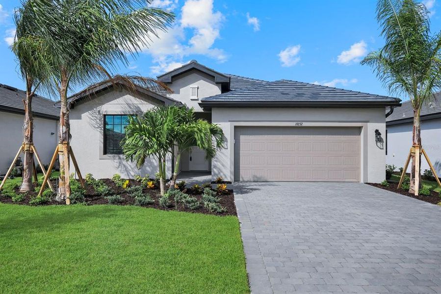 Front exterior of a new home in Verdana Village, Estero, FL, highlighting curb appeal (Image 2).