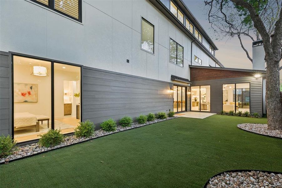 Private turfed backyard with mature trees and seamless indoor-outdoor connection, ideal for relaxing or entertaining.