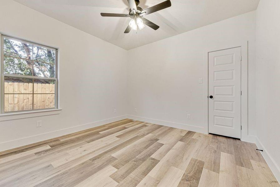 Empty room featuring light wood-style floors and a ceiling fan Empty room featuring light wood-style floors and a ceiling fan