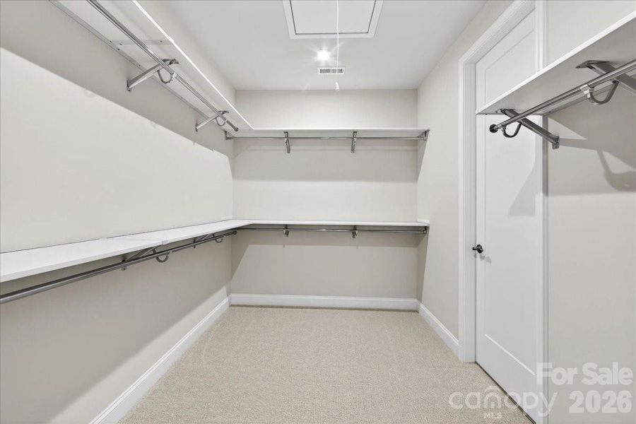 Primary walk-in closet with connection to the laundry room Primary walk-in closet with connection to the laundry room