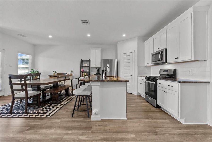 Chef’s eat-in island kitchen boasts stainless steel appliances, 42” cabinets with crown molding, lengthy countertops, breakfast bar seating, and a spacious pantry.