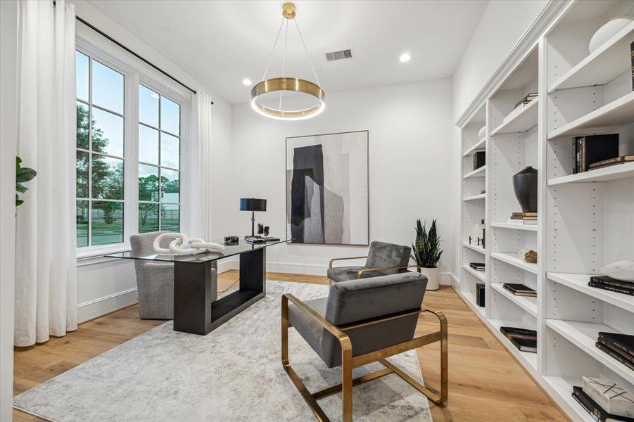 Well-lit home office with large windows and built-ins