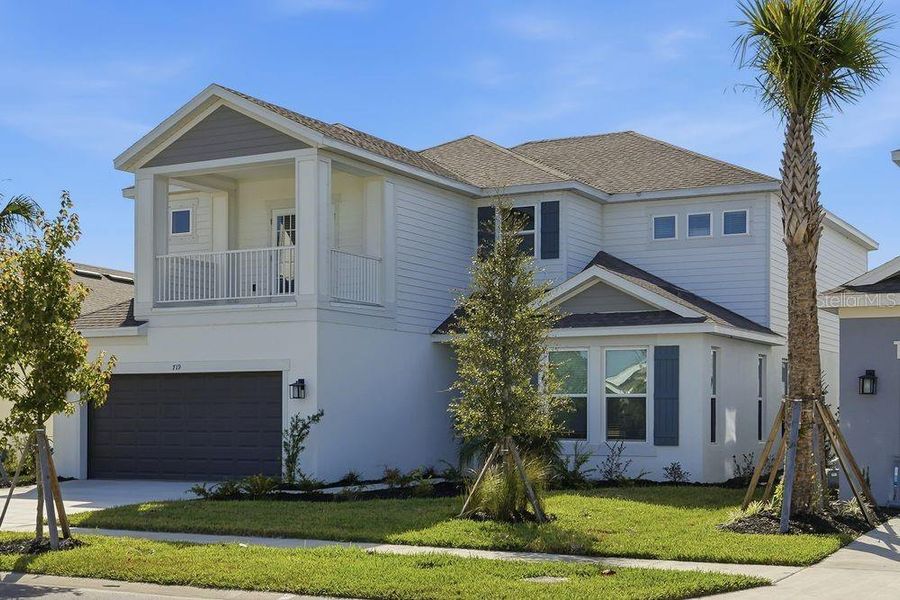 Front exterior of a new home in Indigo Creek, Apollo Beach, FL, highlighting curb appeal (Image 2). Front exterior of a new home in Indigo Creek, Apollo Beach, FL, highlighting curb appeal (Image 2).