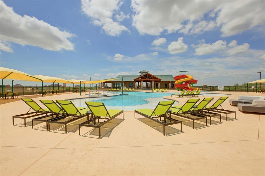 Expansive outdoor pool area featuring a freeform swimming pool, multiple lounge chairs, and shaded seating Expansive outdoor pool area featuring a freeform swimming pool, multiple lounge chairs, and shaded seating